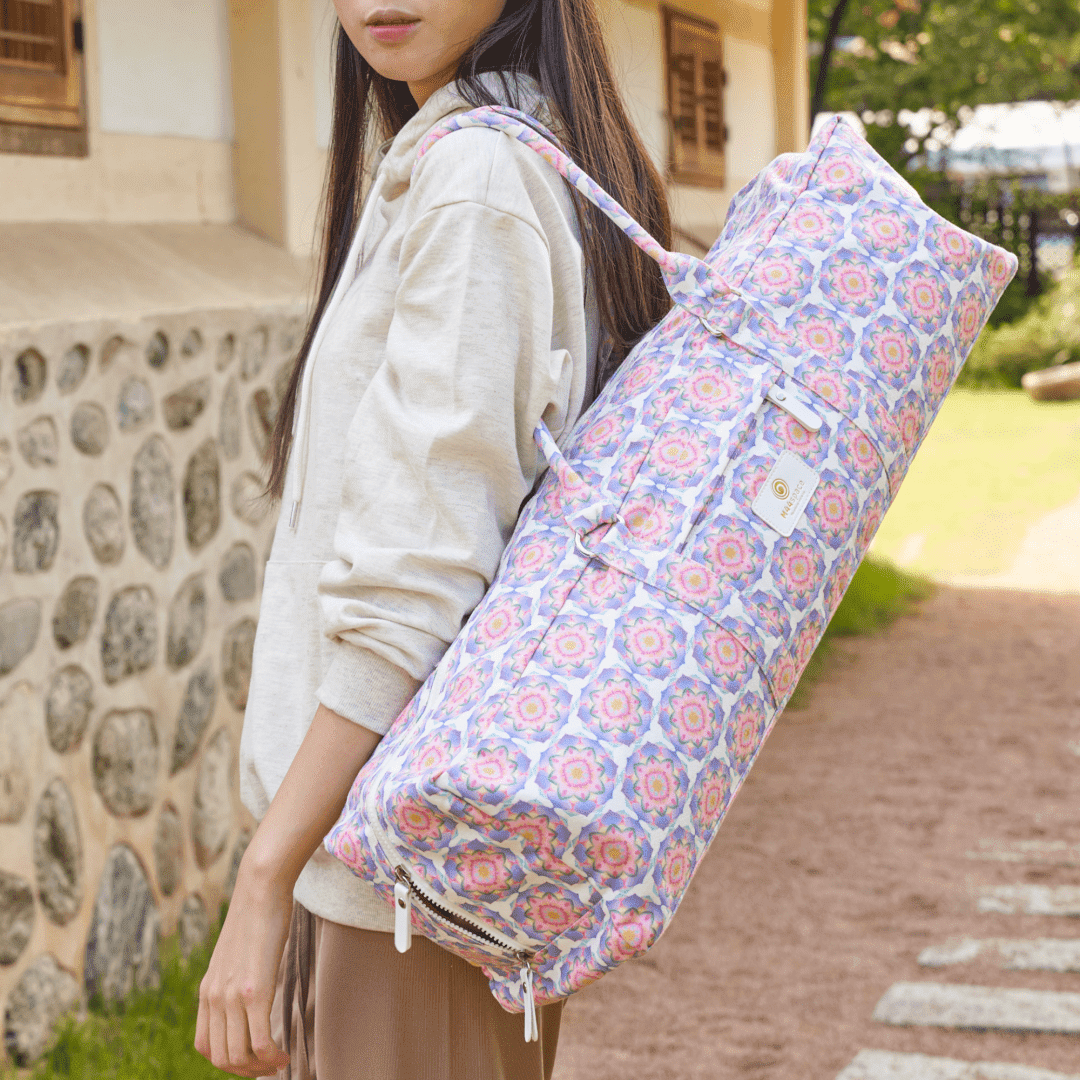 M44space - A woman carrying a lotus-patterned yoga bag stands in front of an old stone wall