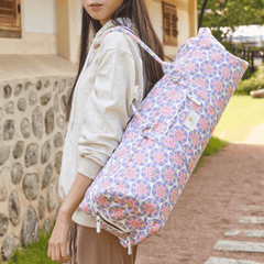 M44space - A woman carrying a lotus-patterned yoga bag stands in front of an old stone wall